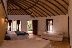 圣佩德罗·德·阿塔卡马Lodge Atacama Horse的带窗户的客房内设有三张床。