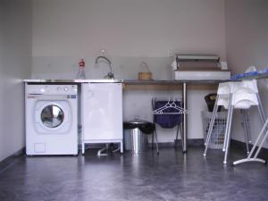 奥萨Hansjö Stugby - Mickolavägen的洗衣房配有洗衣机和水槽