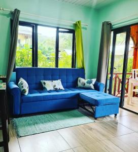 拉迪格岛卡萨德里拉自助旅馆的客厅设有蓝色的沙发,配有窗户