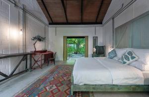 NolhivaranfaruMi Lugar Maldives的一间卧室配有一张床和一张书桌