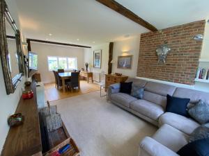 SandhurstAmazing cottage right in the heart of Ewhurst Green, overlooking Bodiam Castle的带沙发和砖墙的客厅