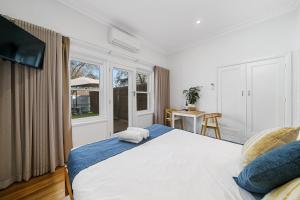 贝纳拉本森旅馆公寓的卧室设有一张白色大床和一扇窗户。