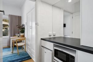 贝纳拉本森旅馆公寓的厨房配有白色橱柜和黑色台面