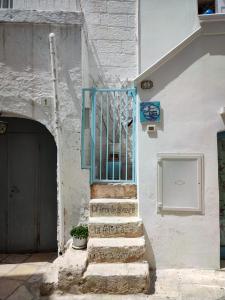 滨海波利尼亚诺La Casa Di Nicole的一座设有蓝色门的楼梯的建筑