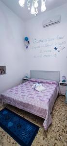 滨海波利尼亚诺La Casa Di Nicole的一间卧室配有一张带紫色棉被的床