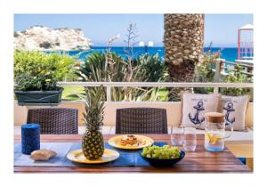 利加里亚Beachfront Blue apt-Ligaria beach的一张木桌,上面放着食物和水果盘
