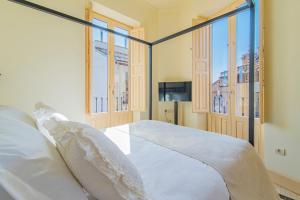 格拉纳达Mosaiko Homes Catedral Granada的一间卧室设有一张床和两个窗户。