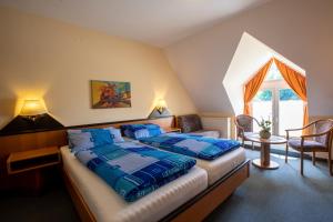 塞布尼茨Hotel Brückenschänke的一间卧室配有一张带蓝色棉被的床和窗户