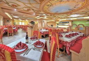 佛加里达Hotel Madonna delle Nevi的餐厅配有桌椅和红色餐巾