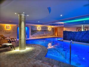 佛加里达Hotel Madonna delle Nevi的蓝色灯光的房子里的一个游泳池