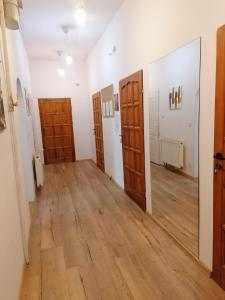 什切青Hostel Tulip - Pokój 1 ze wspólną łazienką i kuchnią的带门的房间和铺有木地板的走廊