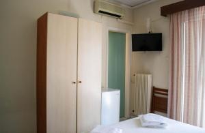 约阿尼纳Egnatia Hotel的一间带白色橱柜和电视的卧室