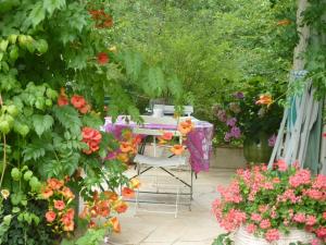 LuzechL'orée du bois的花园里种满鲜花,配有桌椅