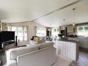 威尔汉姆Hill View, Lilac Lodge的一间带两张沙发的客厅和一间厨房