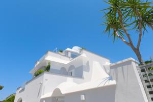 伊斯基亚Mavilan Luxury Apartments Ischia的前方有棕榈树的白色建筑