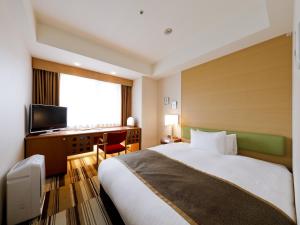 大阪路德会酒店的酒店客房配有一张床、一张书桌和一台电视。