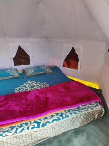 瑞诗凯诗TRIBE AQUA a nature retreat above Neer waterfall的紫色毯子帐篷内的一张床位
