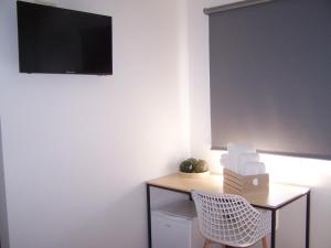 科尔库维翁Albergue San Pedro的一间房间,配有一张桌子和一台墙上的电视