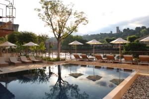 明乔河畔的瓦雷奇奥Corte Regia Relais & Spa的游泳池,带椅子和遮阳伞