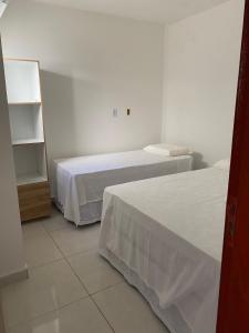 马拉戈日Mellim Residence的一间卧室设有两张床和书架