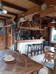 勒奥瓦尔德Au petit coin western的厨房配有桌子和带酒吧凳的酒吧