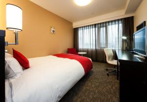 冈山达维奥雅玛艾克玛酒店的酒店客房配有一张床、一张书桌和一台电视。
