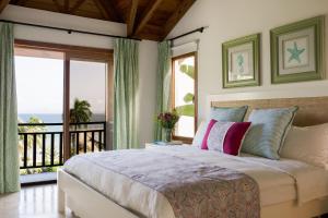 圣塔芭芭拉-山美纳Ocean View Villa/Luxury Puerto Bahia Resort/Samaná的一间带大床的卧室和一个阳台