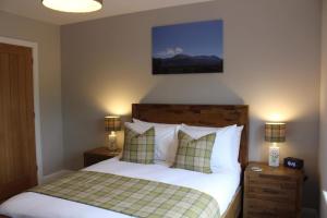 史宾桥Stag Lodge的一间卧室配有一张带2个床头柜和2盏灯的床。