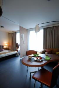 波尔多波尔多艾达吉奥公寓式酒店的一间带桌子的客厅和一间卧室
