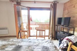 OzOz Appartement cosy 3 chambres的客厅设有滑动玻璃门,通往阳台