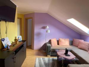 豪伊杜索博斯洛Julius Apartman的带沙发和紫色墙壁的客厅