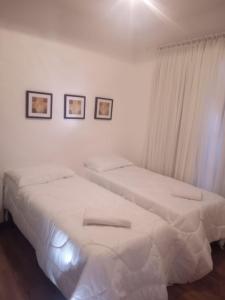 格拉玛多Resort com Natureza no Centro的白色墙壁客房的两张床