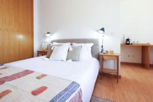 VilarinhoCasa do Condado的卧室设有一张白色大床和木地板