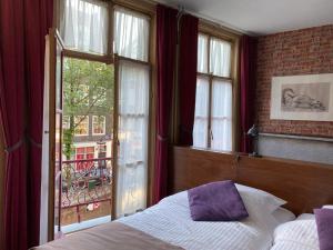 阿姆斯特丹Hotel & bar Royal taste Amsterdam的一间卧室设有一张床和一个大窗户