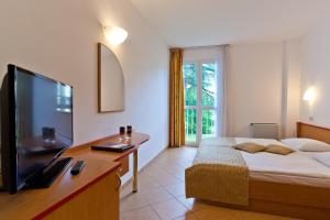 克尔克Villa Lovorka - Hotel Resort Dražica的一间卧室配有一张床和一台平面电视