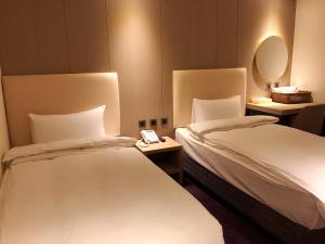 罗东镇米淇旅店 - 罗东馆 的酒店客房,设有两张床和镜子