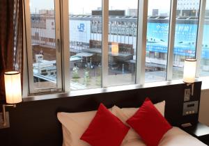 冈山达维奥雅玛艾克玛酒店的带窗户的客房内的一张带红色枕头的沙发
