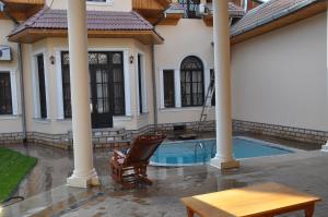 撒马尔罕撒马尔罕萨法尔酒店的一个带游泳池、桌子和椅子的房子