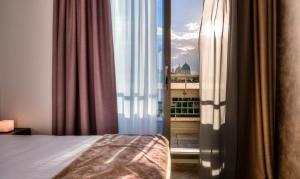 佛罗伦萨十六号城堡景观SPA公寓式酒店的一间卧室设有一张床和一个美景窗户。
