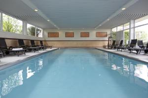 维林根乌瑟尔恩环形普斯特酒店的大楼内带桌椅的大型游泳池