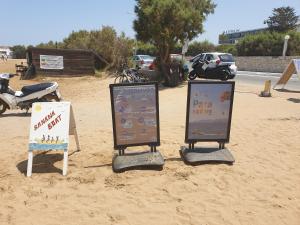 古瓦伊Gouves Sunset apts的沙中三个标志,背后是一辆摩托车