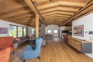 佩特诺伊阿尔贝格Chalet Vega - Arlberg Holiday Home的开放式客厅设有木制天花板和家具。