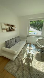 圣吉尔根Seeblick Apartment的客厅配有白色沙发和玻璃桌