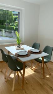 圣吉尔根Seeblick Apartment的餐桌周围设有四把绿色椅子