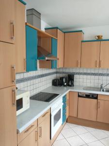 盖布利茨Ferienwohnung Madlene 2的厨房配有木制橱柜和白色家电