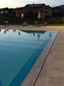 卢卡Agriturismo Casa Rosa的一座游泳池,旁边设有2个长椅