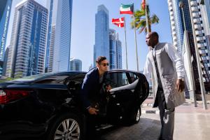迪拜迪拜罗塔纳大厦酒店的两个人站在一辆黑色汽车旁边