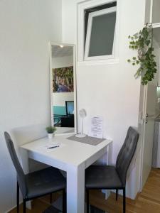 哥廷根Apartment in der Innenstadt的办公室配有书桌、两把椅子和镜子