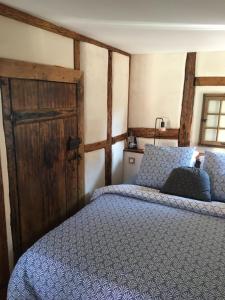当巴克拉维尔Le Petit Cocon的一间卧室配有一张床和一扇木门