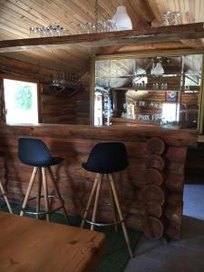 梅马克Glynns at Club Correze的小木屋内的酒吧,设有两张凳子